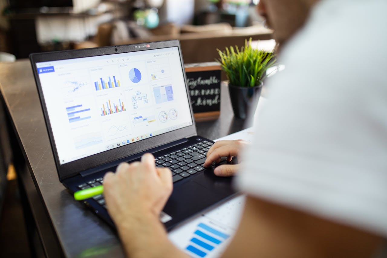 home-services-03 Focused business analysis with charts and graphs on a laptop in a modern office setting.